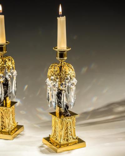 AN UNUSUAL PAIR OF GILT BRONZE MILITARY FIGURE CANDLESTICKS