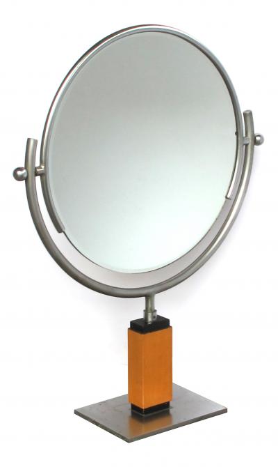 An American art deco steel dressing mirror raised on a maplewood base