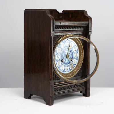 An Anglo Japanese Carved Oak Mantel Clock with Hand Painted Blue Floral Dial
