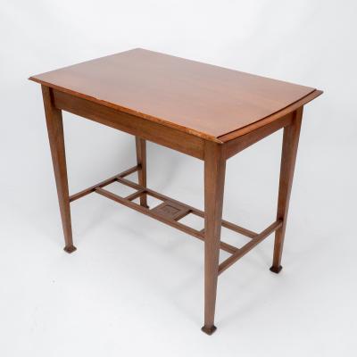 An Arts Crafts Glasgow School walnut side table w moulded subtly curving edge