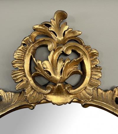 An Elegantly Carved French Louis XV Rococo Giltwood Oval Mirror