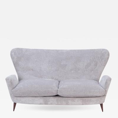 An Italian vintage wingback drop arm upholstered settee 