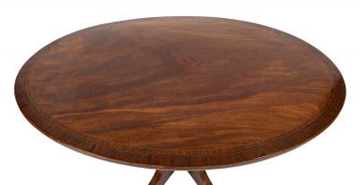 An Oval Regency Triple Banded Tilting Mahogany Breakfast Table