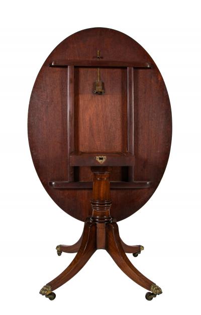 An Oval Regency Triple Banded Tilting Mahogany Breakfast Table