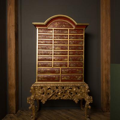An antique chinoiserie lacquer storage cabinet on carved giltwood stand