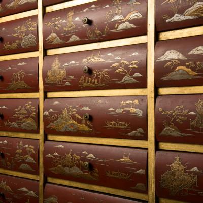 An antique chinoiserie lacquer storage cabinet on carved giltwood stand
