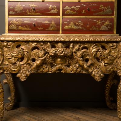 An antique chinoiserie lacquer storage cabinet on carved giltwood stand