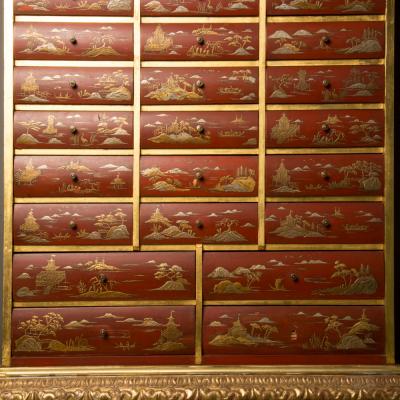 An antique chinoiserie lacquer storage cabinet on carved giltwood stand