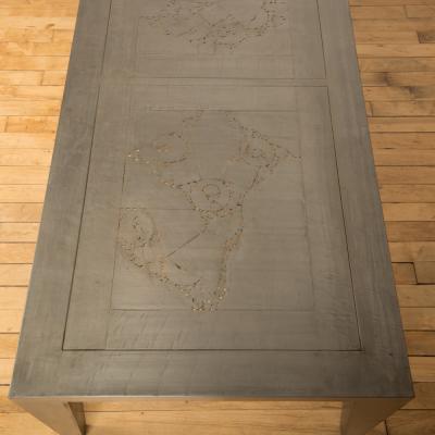 An artist designed metal clad silver color coffee table with holes in top