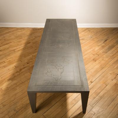 An artist designed metal clad silver color coffee table with holes in top
