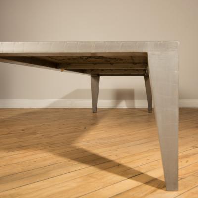 An artist designed metal clad silver color coffee table with holes in top