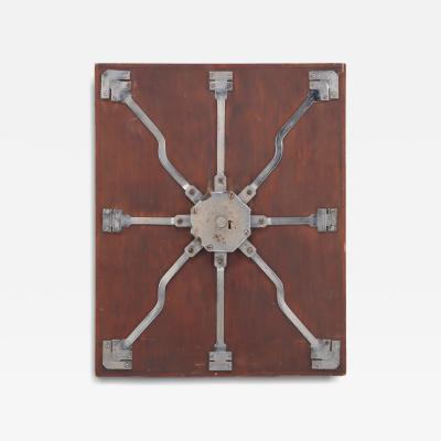 Antique steel lock mechanism mounted on a wooden board 