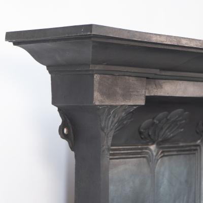 Arts Crafts cast iron fireplace with curved sides stylized floral decoration