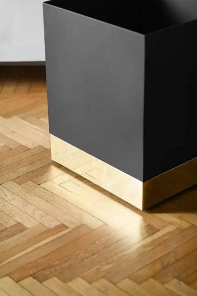 Black enamelled metal vase holder with brass details and invisible wheels
