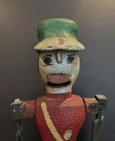 Carved and painted wood Whirligig of a soldier wearing red coat and a green hat 