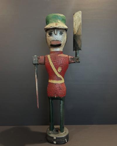 Carved and painted wood Whirligig of a soldier wearing red coat and a green hat 