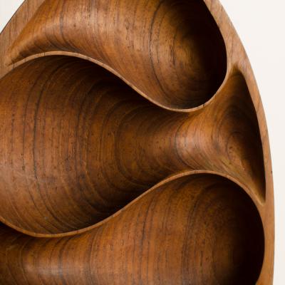 Carved wood almond shaped sculpture and base 