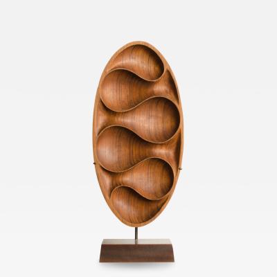 Carved wood almond shaped sculpture and base 