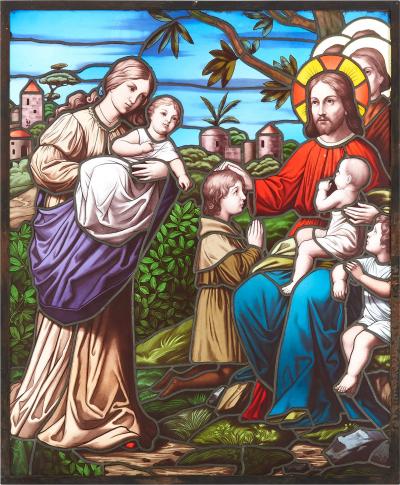 Christian stained glass window of Christ blessing children