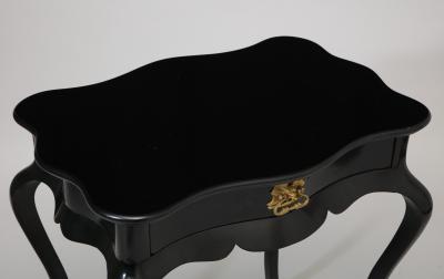 Dramatic ebonized side table with bat drawer pull