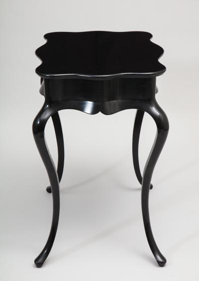Dramatic ebonized side table with bat drawer pull