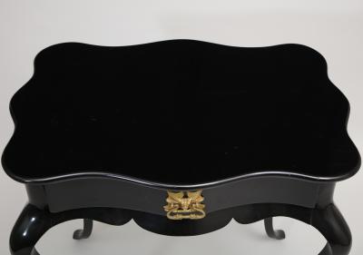 Dramatic ebonized side table with bat drawer pull