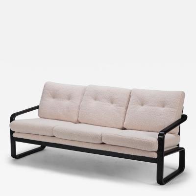 Ebonized French three seat sofa recently upholstered in Boucle fabric