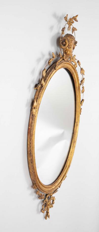 English George III Oval Hepplewhite Gilded Mirror with Rams Head Surmount