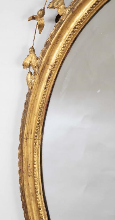 English George III Oval Hepplewhite Gilded Mirror with Rams Head Surmount