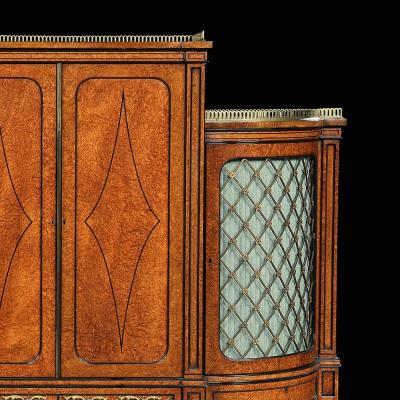 FINE REGENCY AMBOYNA AND EBONY INLAID GILT BRONZE MOUNTED SHAPED CABINET