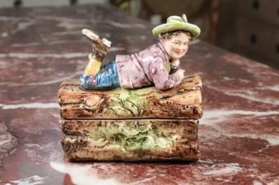 French 19th Century Barbotine Bonbon Box Depicting a Boy Laying on a Tree Trunk
