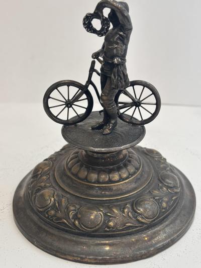 German silver plate chalice with floral relief and bicycle rider finial on lid