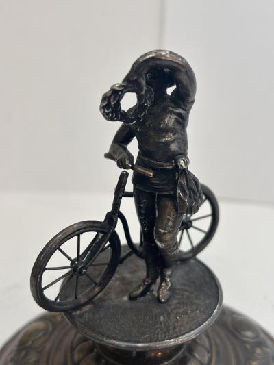 German silver plate chalice with floral relief and bicycle rider finial on lid