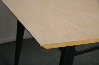Laminated beech top and black lacquered wood base with brass tipped legs 