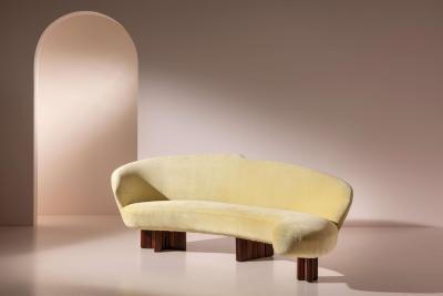 Large curved sofa with carved wooden supports Italy 1950s