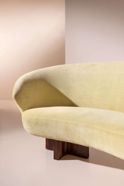 Large curved sofa with carved wooden supports Italy 1950s