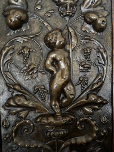 PAIR of French Victorian oak framed brass embossed cupid wall plaques