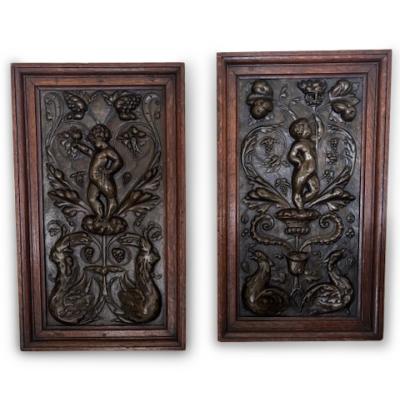 PAIR of French Victorian oak framed brass embossed cupid wall plaques