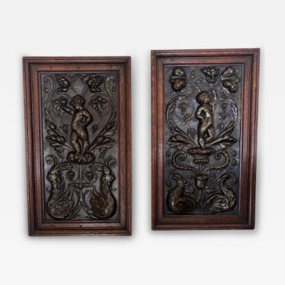 PAIR of French Victorian oak framed brass embossed cupid wall plaques