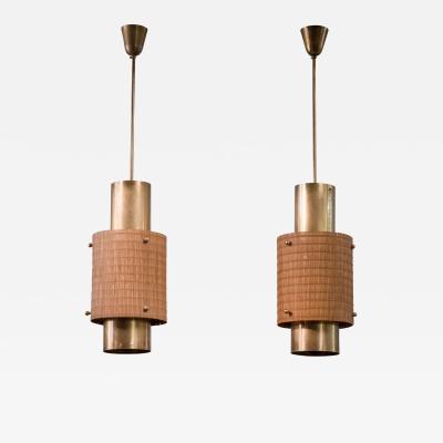 Paavo Tynell Pair of Paavo Tynell brass and wood pendant lamps