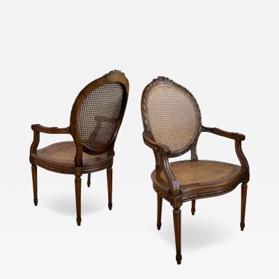 Pair Louis XVI Style Carved Walnut Arm Chairs with Caned Back Seat