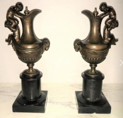 Pair of 19th Century Urns on Marble Stands Bearing Cherubs and Rams Heads