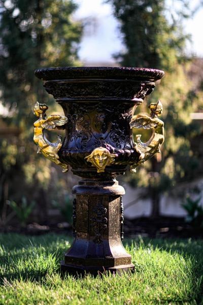 Pair of Antique French Rococo Style Black Iron Urns Adorned with Brass Figures