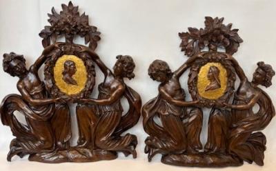 Pair of Italian wall plaques of 2 kneeling figures hold an oval frame portrait