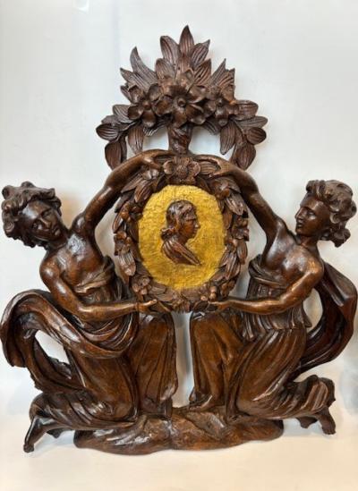 Pair of Italian wall plaques of 2 kneeling figures hold an oval frame portrait