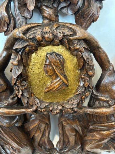 Pair of Italian wall plaques of 2 kneeling figures hold an oval frame portrait