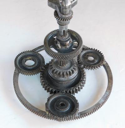 Pair of industrial cast iron gear wheel tables with circular glass tops