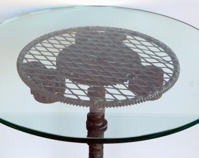 Pair of industrial cast iron gear wheel tables with circular glass tops