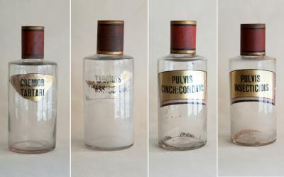 SET OF FOUR HAND BLOWN GLASS APOTHECARY BOTTLES WITH GILT AND RED TOPS