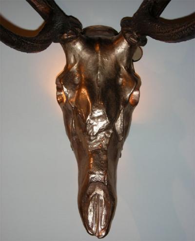 Two 1970s sconces shaped like a deers skull with antlers